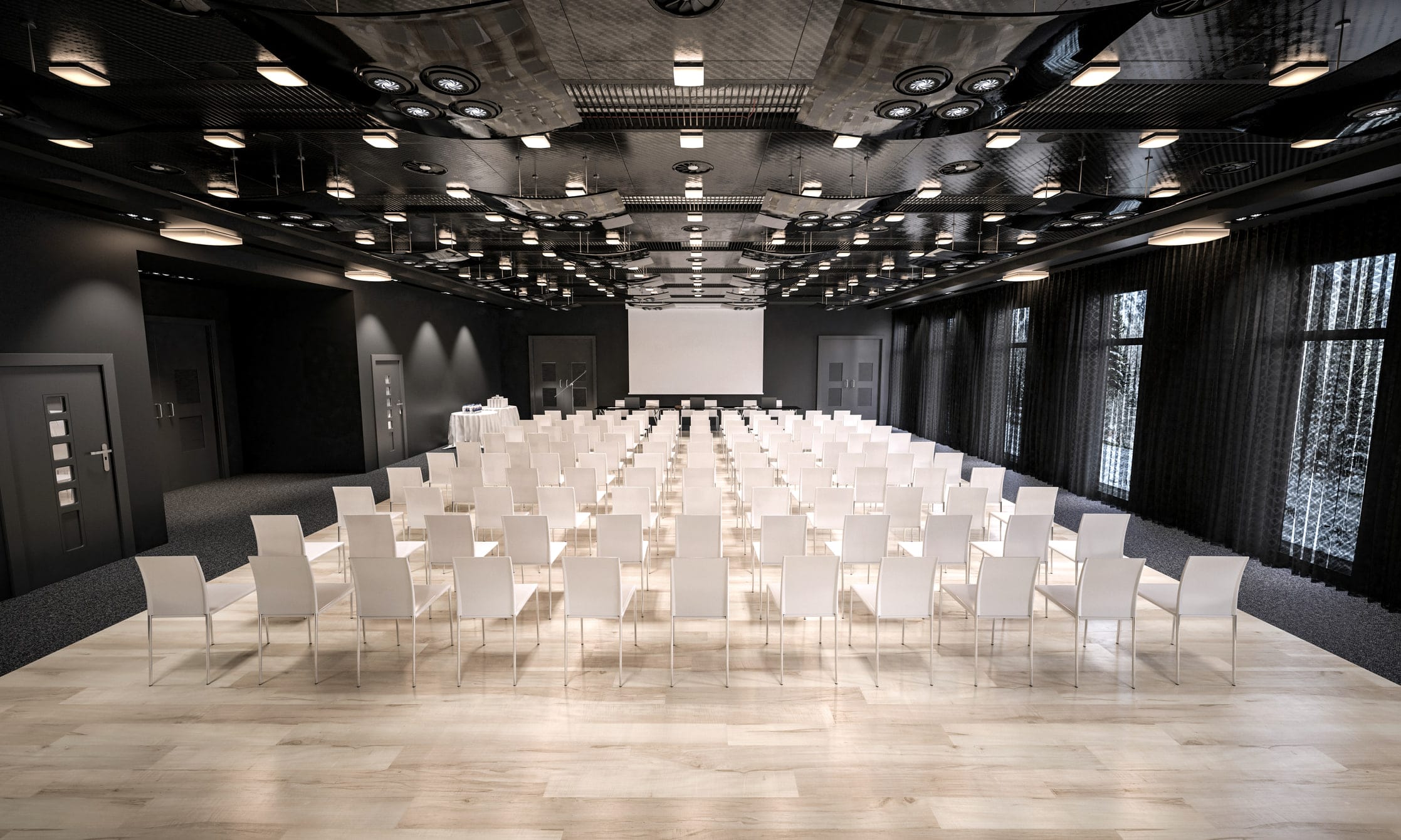 An empty training hall laid out with rows of white chairs facing a screen.